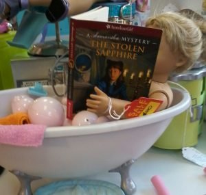 doll reading book in bathtub