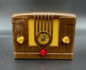 Doll-sized 1940's style radio, with brown marbled plastic and gold plastic details