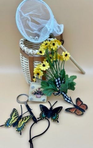 A basket, pretend butterflies, yellow faux flowers, magnifying glass on a cord, wooden flower press, and fabric net with wood handle. Excellent condition.